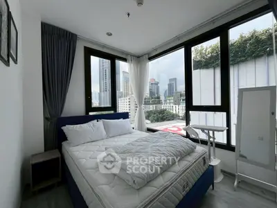 Modern bedroom with city view, large windows, and stylish decor