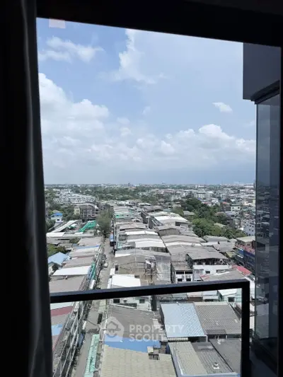Stunning cityscape view from a high-rise balcony, showcasing expansive urban landscape under a clear blue sky.