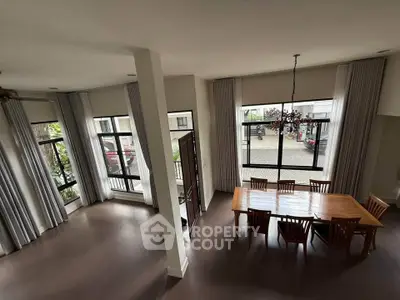 Spacious dining area with large windows and elegant chandelier in modern home