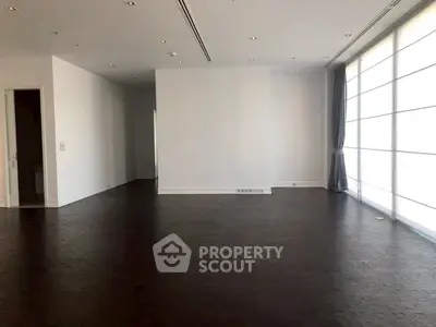 Spacious modern living room with dark wood flooring and large windows