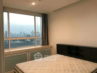 Spacious bedroom with large window offering stunning city skyline view, ideal for urban living.