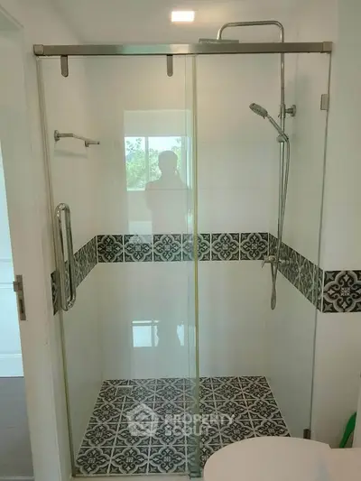 Modern bathroom with stylish shower and patterned tiles