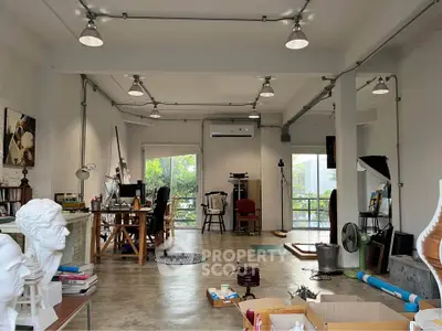 Spacious industrial-style studio with concrete floors and ample natural light, perfect for creative work.