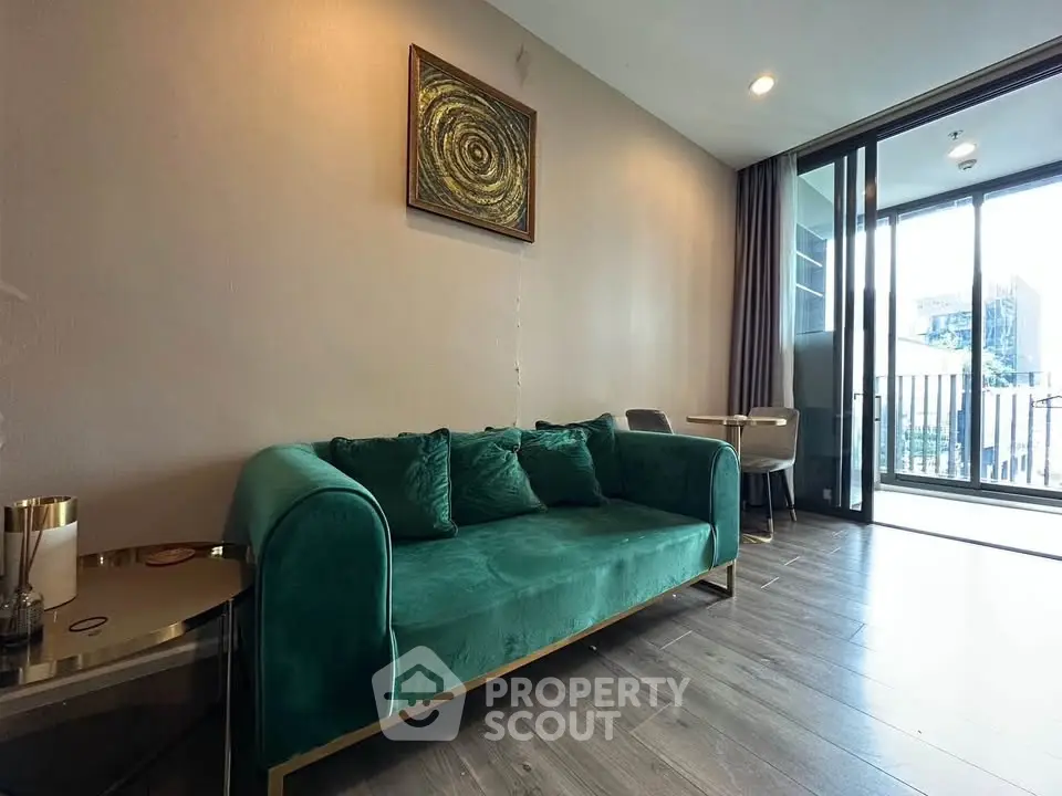 Modern living room with green velvet sofa and balcony view