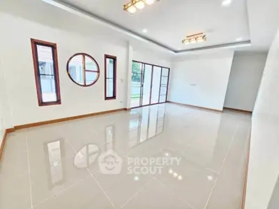 Spacious modern living room with elegant lighting and large windows for natural light.