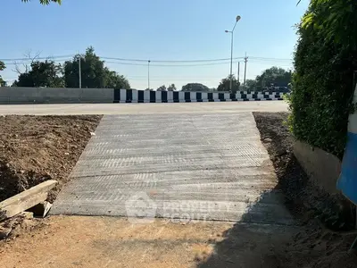 Newly constructed driveway leading to a main road with clear blue sky