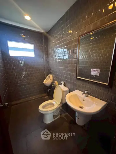 Modern bathroom with sleek dark tiles and contemporary fixtures.