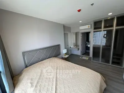Spacious modern bedroom with ensuite bathroom and city view, featuring sleek design and ample natural light.