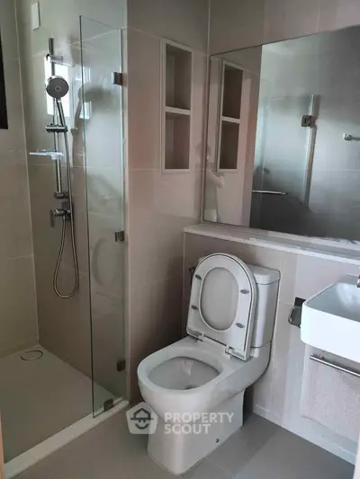 Modern bathroom with glass shower and sleek fixtures in a contemporary apartment.