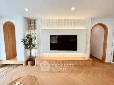 Modern living room with stylish wood accents and large wall-mounted TV