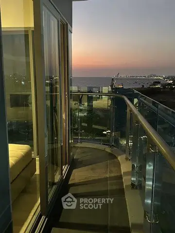 Stunning balcony view at sunset with glass railing and ocean backdrop