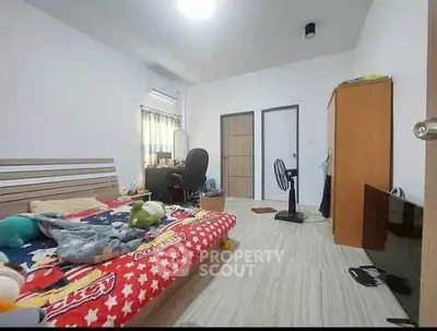 Spacious bedroom with modern decor and ample natural light, featuring a cozy bed and functional workspace.