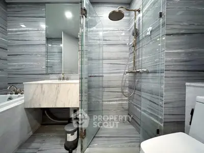Luxurious modern bathroom with glass shower and marble finishes