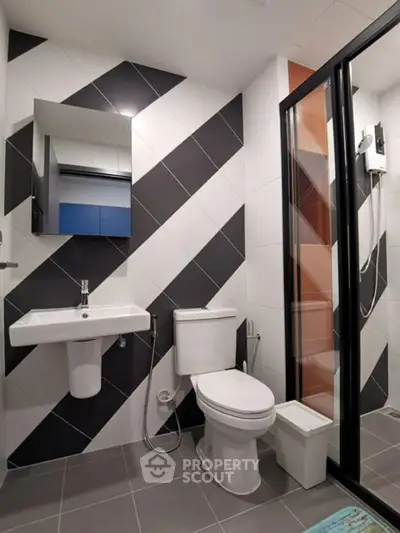 Modern bathroom with stylish geometric tiles and glass shower enclosure
