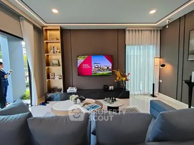 Luxurious modern living room with elegant decor and large TV, perfect for relaxation and entertainment.