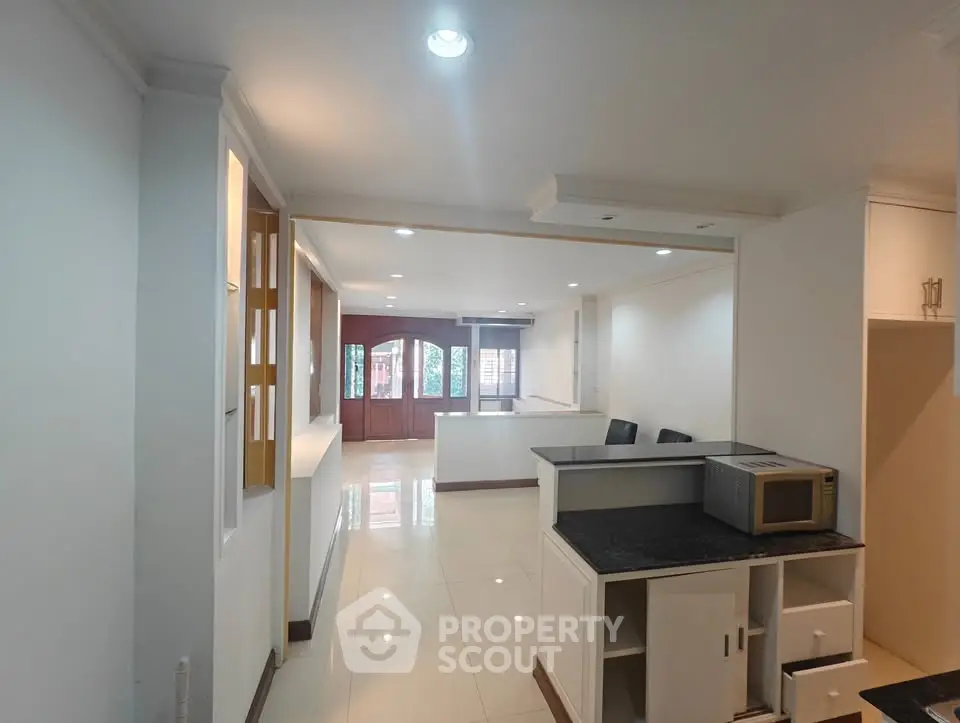 Spacious open layout living area with modern kitchen and ample natural light.