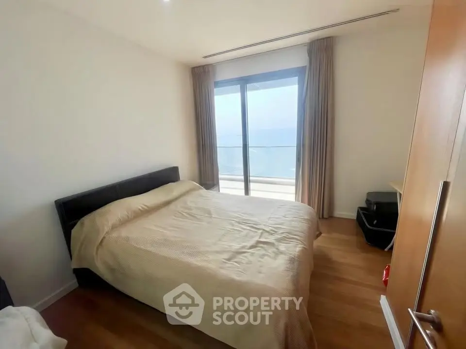 Spacious bedroom with balcony and ocean view in modern apartment