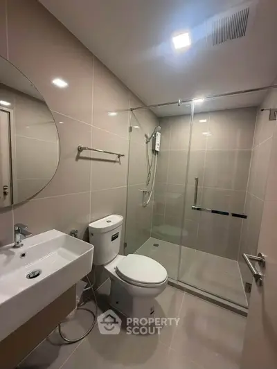 Modern bathroom with glass shower enclosure and sleek fixtures