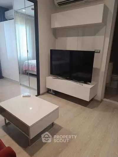 Modern living room with sleek TV setup and mirrored closet doors