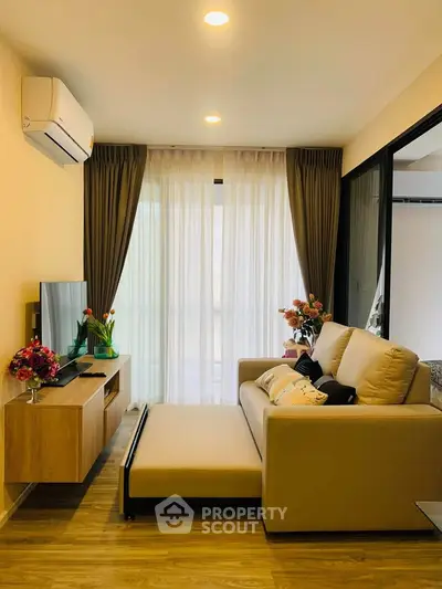 Cozy living room with modern decor, featuring a comfortable sofa, TV, and elegant curtains.