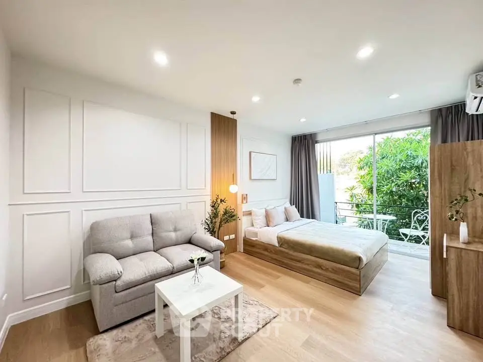 Spacious modern living room with cozy sofa and elegant decor, featuring a large window with garden view.