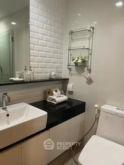 Modern bathroom with sleek design, featuring a stylish sink and elegant decor.