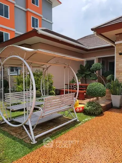 Charming garden view with stylish swing and lush greenery in modern residential property.