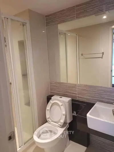 Modern bathroom with sleek design featuring a glass shower and contemporary fixtures.