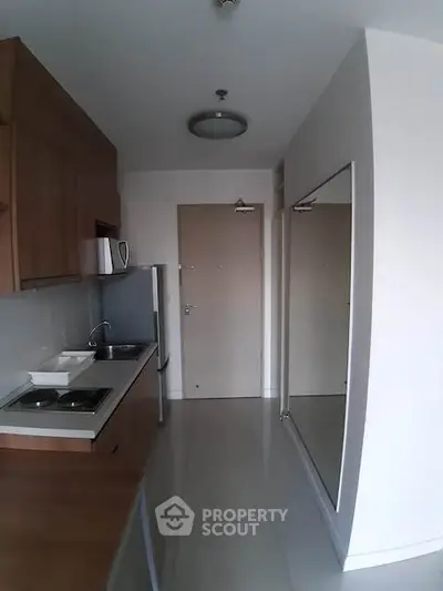 Modern kitchen with sleek cabinetry and compact design, featuring a built-in sink and stove.