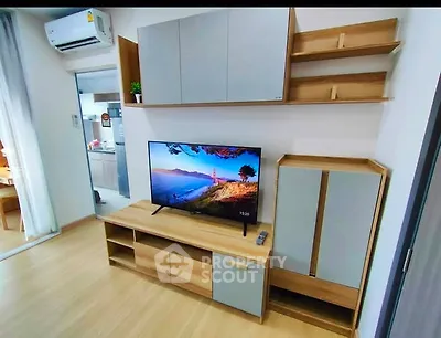 Modern living room with stylish TV stand and wall-mounted storage, featuring a sleek air conditioner.