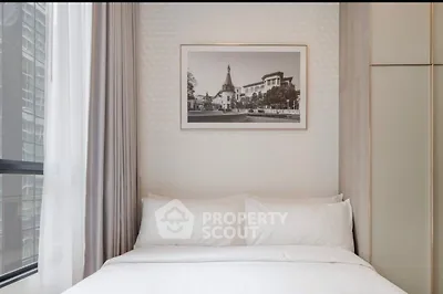 Cozy bedroom with elegant decor and large window in modern apartment.