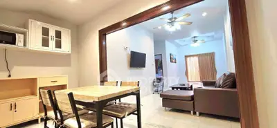 Spacious open-plan living and dining area with modern furnishings and ceiling fans.