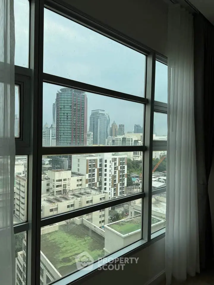 Stunning cityscape view from a high-rise apartment window, showcasing urban skyline.