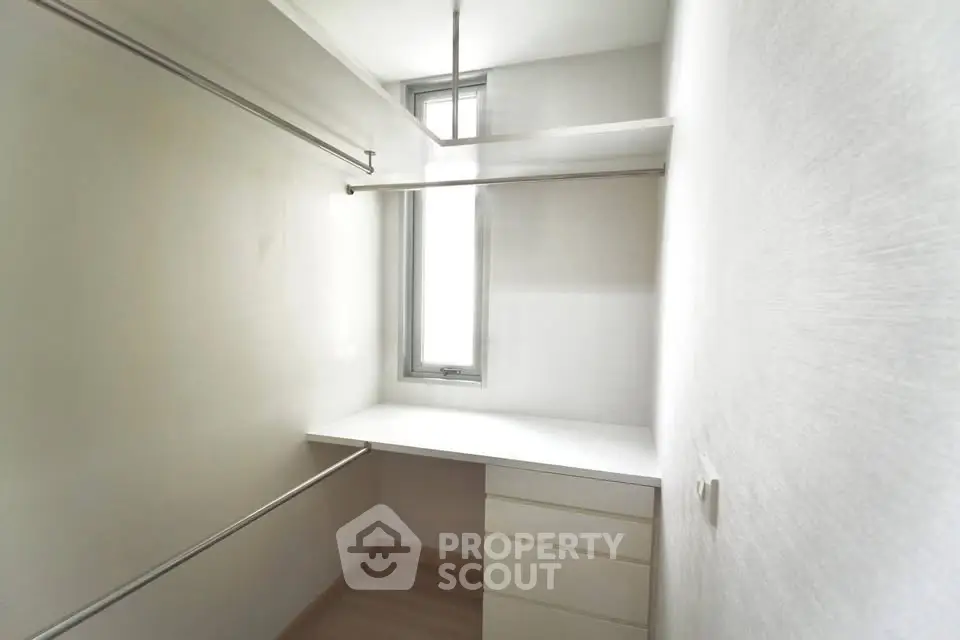 Spacious walk-in closet with natural light and ample storage space.