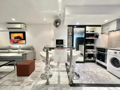 Modern open-plan living room with sleek kitchen and stylish furniture in a contemporary apartment.