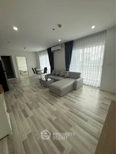 Spacious modern living room with elegant decor and large windows for natural light.
