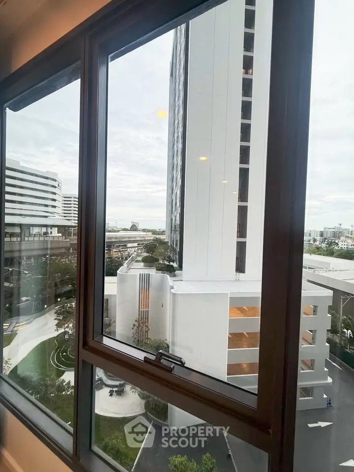 Stunning urban view from a modern apartment window showcasing cityscape and high-rise buildings.