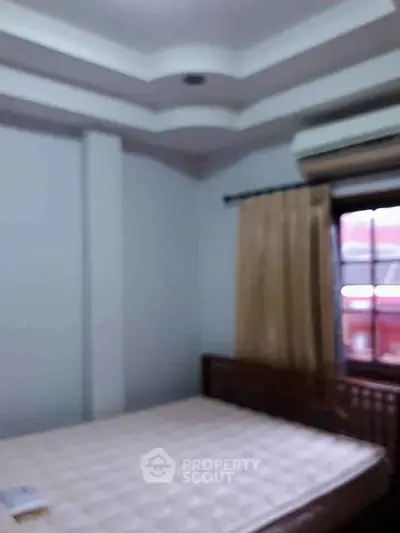 Cozy bedroom with natural light and modern ceiling design.