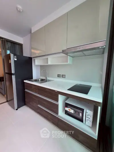 Modern kitchen with sleek cabinetry, built-in appliances, and minimalist design in a contemporary apartment.