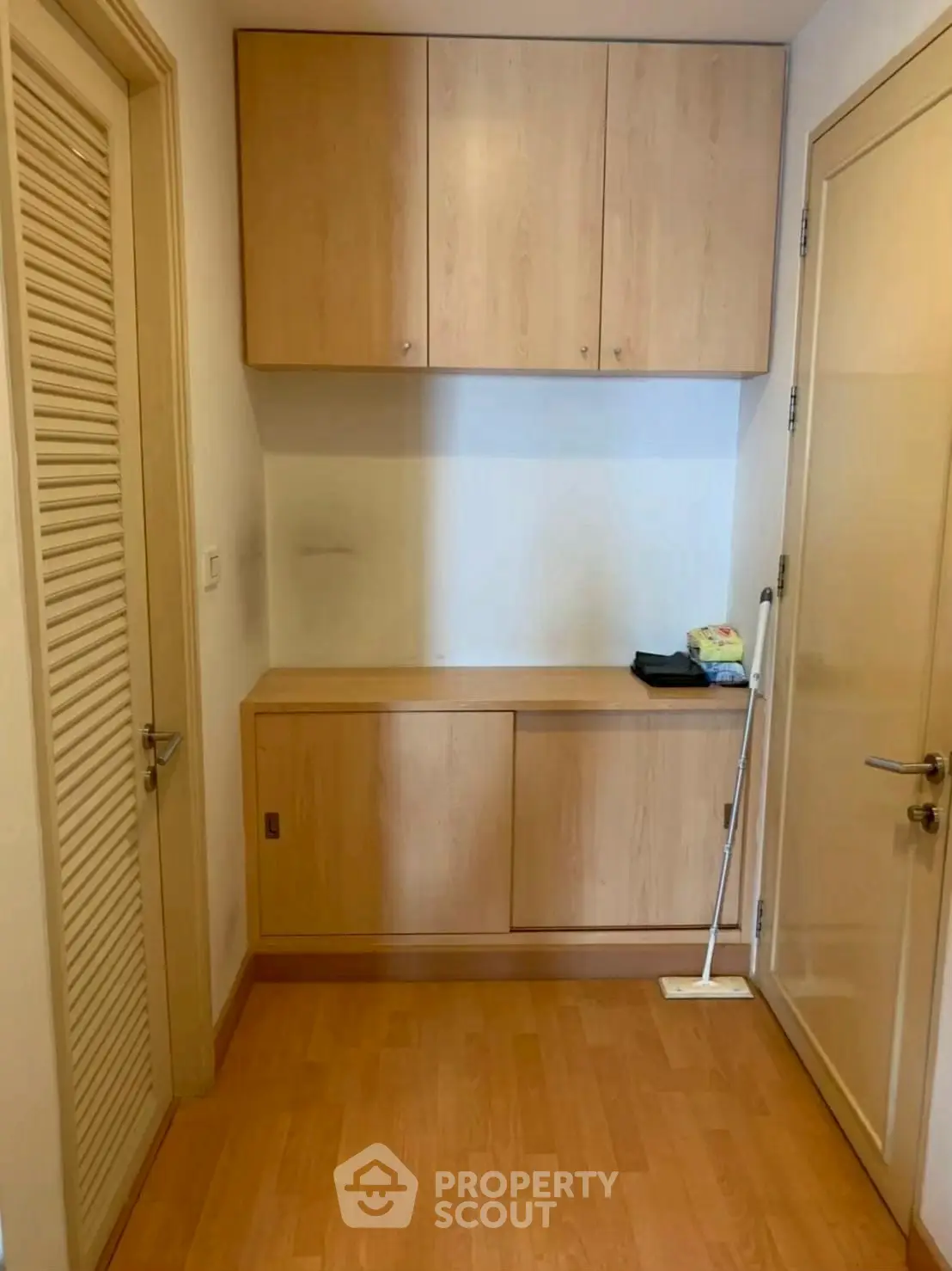 Compact storage area with wooden cabinets and laminate flooring