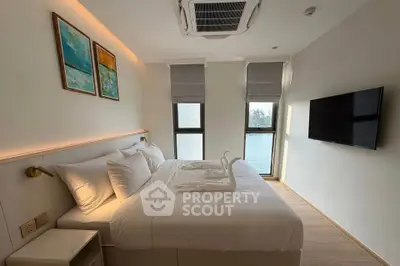 Modern bedroom with stylish decor and large windows offering natural light.