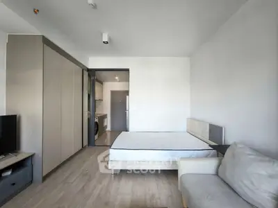 Modern minimalist bedroom with sleek furniture and open kitchen view