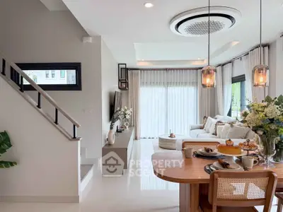 Elegant living room with modern decor, large windows, and stylish dining area, perfect for family gatherings.