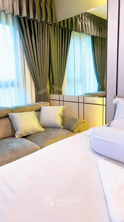 Luxurious bedroom with elegant curtains and plush sofa, perfect for relaxation.