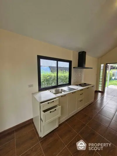 Modern kitchen with sleek cabinetry and garden view, perfect for culinary enthusiasts.