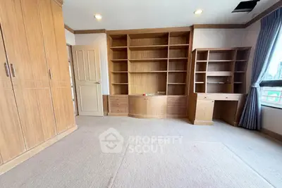 Spacious study room with built-in wooden shelves and ample natural light