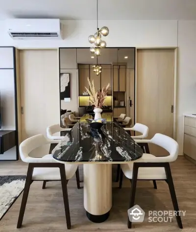 Modern dining area with elegant black marble table and stylish chairs, featuring contemporary lighting and wooden accents.