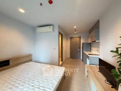 Modern studio apartment with sleek kitchen and cozy bedroom area, perfect for urban living.