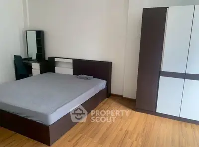 Spacious bedroom with modern furniture and wooden flooring
