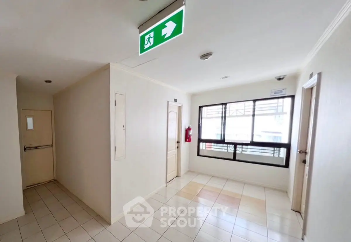 Bright corridor with emergency exit sign in modern building